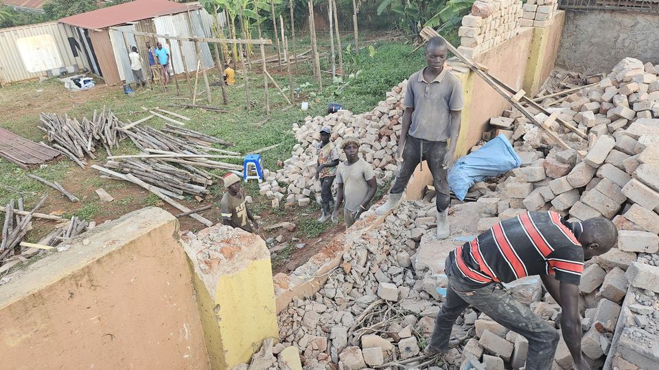 Workers clearing bricks and rubble on a church construction site