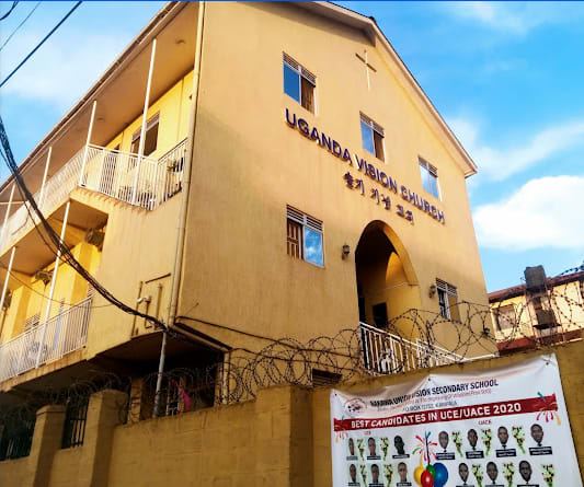 Yellow multi-storey building with the Uganda Vision Church sign
